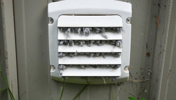 An external vent clogged with bunches of lint buildup