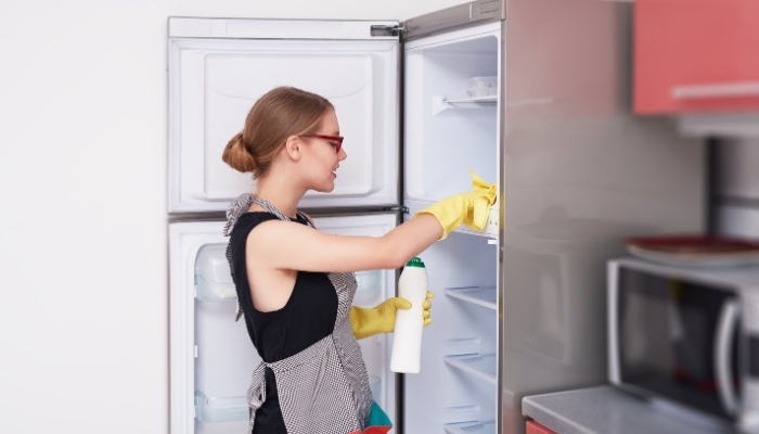 Woman doing a deep clean of her fridge