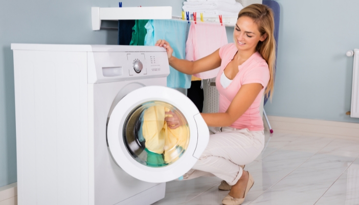 Serv_Off-Balance-Washer_1.jpg Woman loading washing machine with clothes