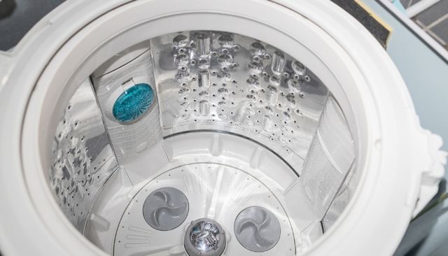 Front view of an opened and empty washing machine off balance