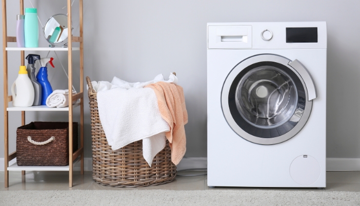 Serv_Off-Balance-Washer_4.jpg A perfectly level washing machine is next to laundry basket and a shelf full of laundry things