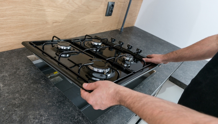 Brand new gas cooktop being installed in the counter