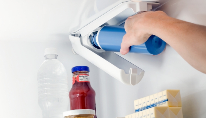 Closeup of someone changing the water filter in a refrigerator