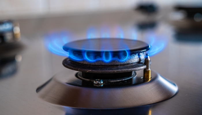 Closeup of a range burner with a blue fame