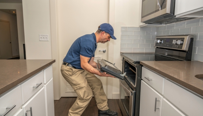 Service repairman fixing the oven door on a range