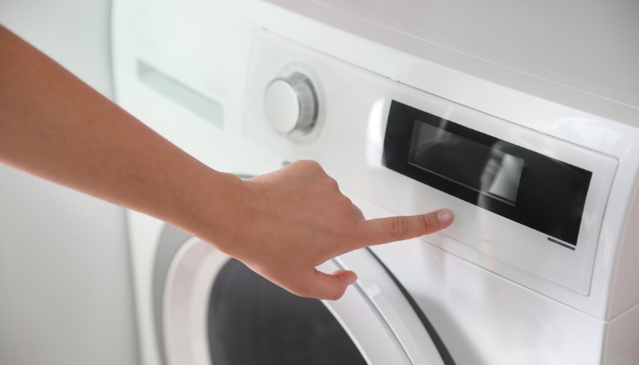 Serv_Washing-Machine-Control-Panel-Issues_1.jpg Closeup of someone pressing buttons on a washing machine but nothing happens