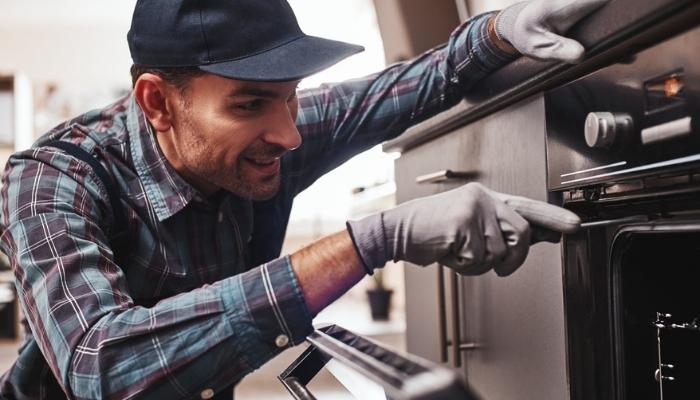 repairman examining oven