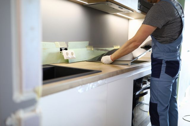View of a man installing an induction cooktop