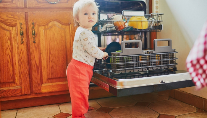Small toddler opening dishwasher