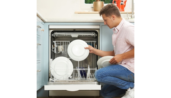 Man pulling dishes out of dishwasher