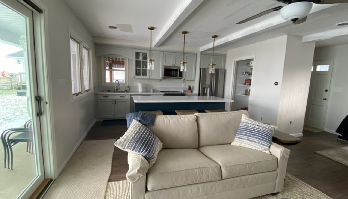 updated living room of lakeside home with fresh paint, new light fixtures, and new furniture