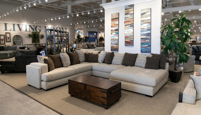 An image of a furniture showroom focusing on a neutral colored L-shaped couch.