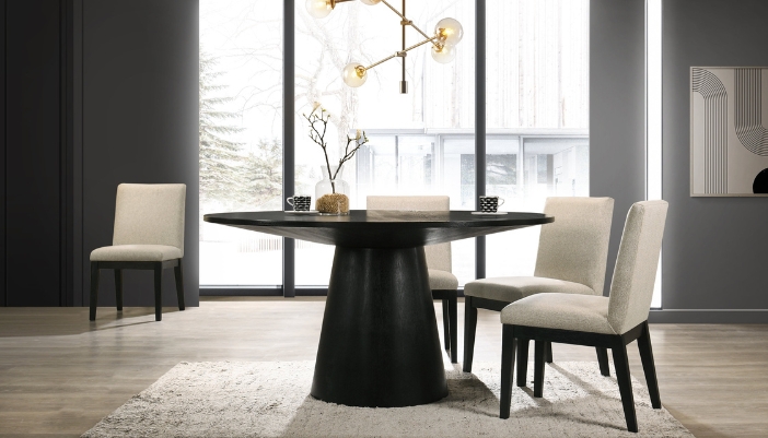 A small circular black table with three white dining chairs.