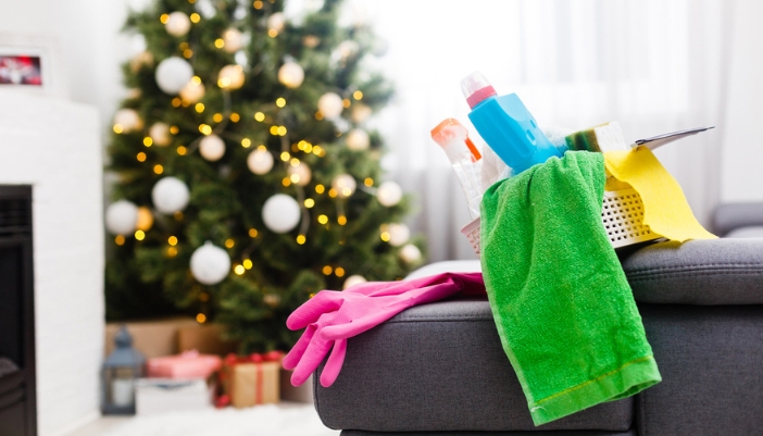 Cleaning supplies sit in a bucket with a holiday tree in the background.