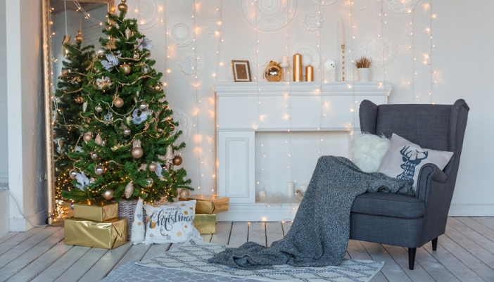 A living room decorated in greens, whites, and lights for the holiday.