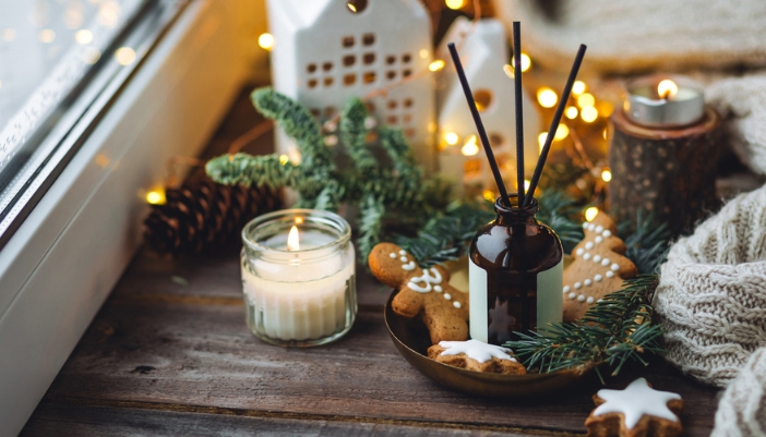 A holiday scented essential oil sits in the middle of holiday decorations.