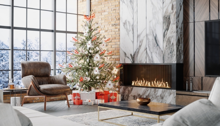 A modern living room with a modern decorated holiday tree and a fireplace.