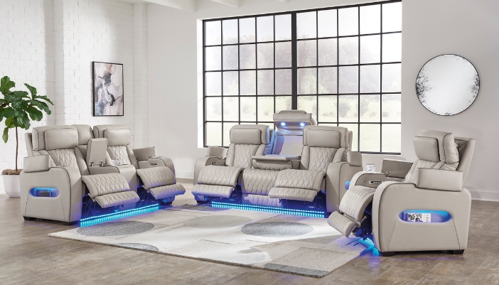 A set of tan reclining leather furniture with blue lights reflecting underneath.