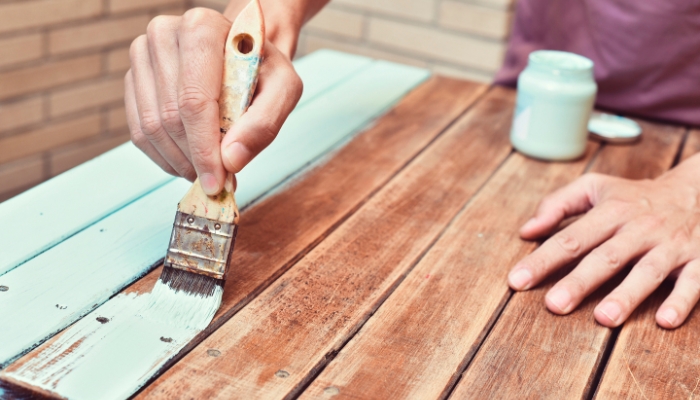 Closeup of someone refinishing a table; DIY concept