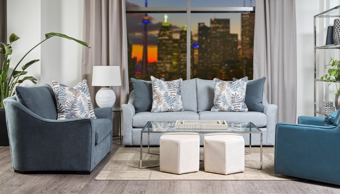 A cozy living room with many greenery plants and blue furniture pieces.
