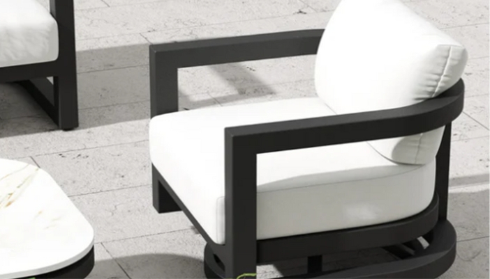A close-up of a white and black patio chair outdoors on a patio.