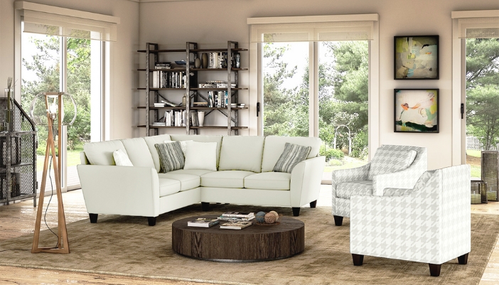A modern living room with white furniture and brightly lit.