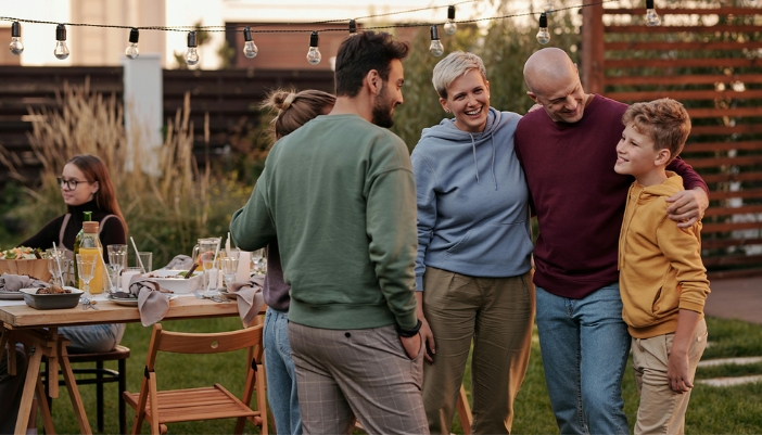 A family celebrates at an outdoor BBQ.