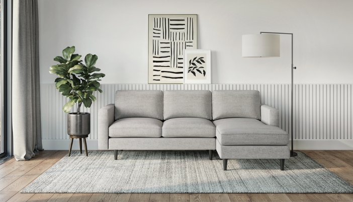A living room featuring an L-shaped gray couch and modern accents.