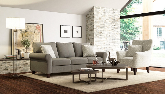 A modern living room with brick wall accents and dark gray furniture.