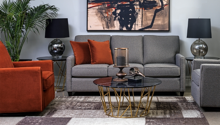 A living room with greenery and a gray couch with other modern touches.