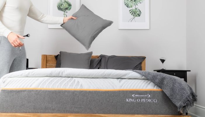A male puts together his bed at home with gray accents.