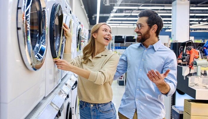 A man and open look at laundry options in an appliance showroom.