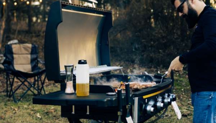 man standing and cooking at griddle
