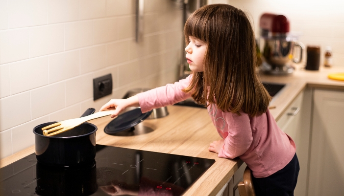 Young girl safely stirring a pot on an induction stove
