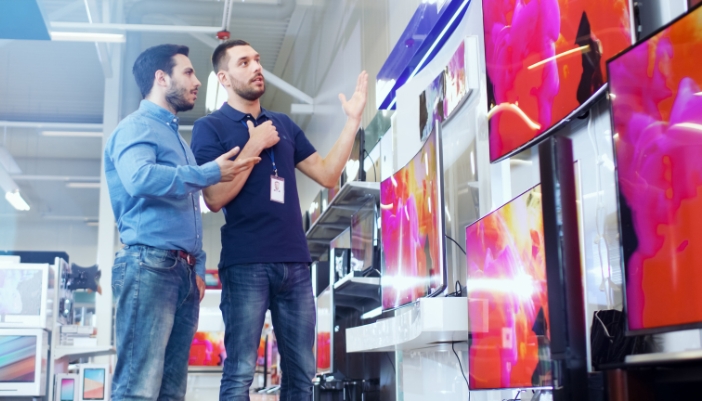 Salesman going over TV choices with consumer