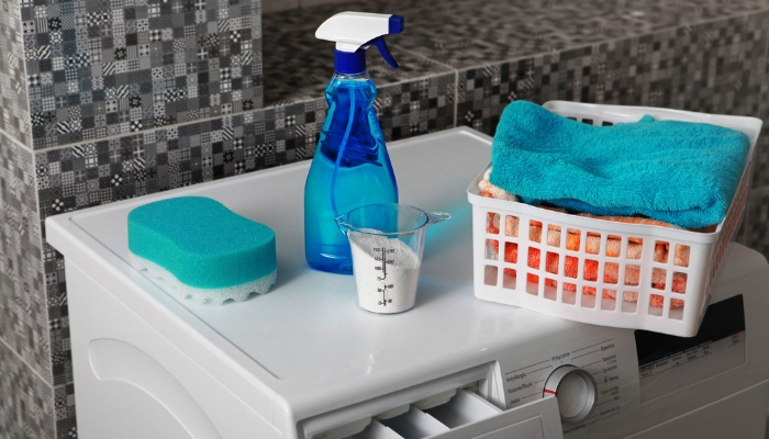 Assortment of cleaning products and towels on top of washer