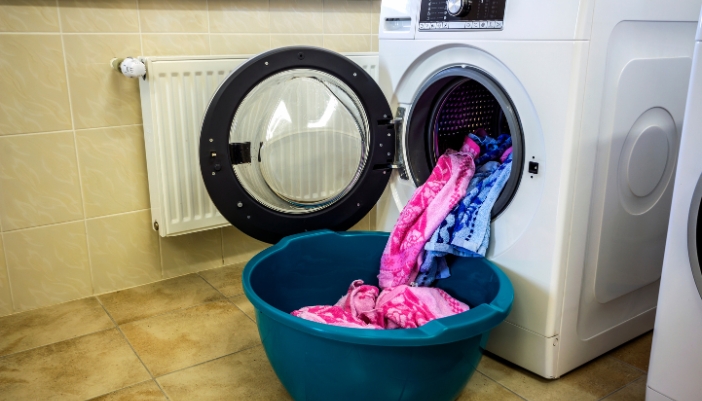 A washer with a full load of clothes spilling out