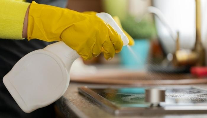 Person spraying cleaner on stovetop