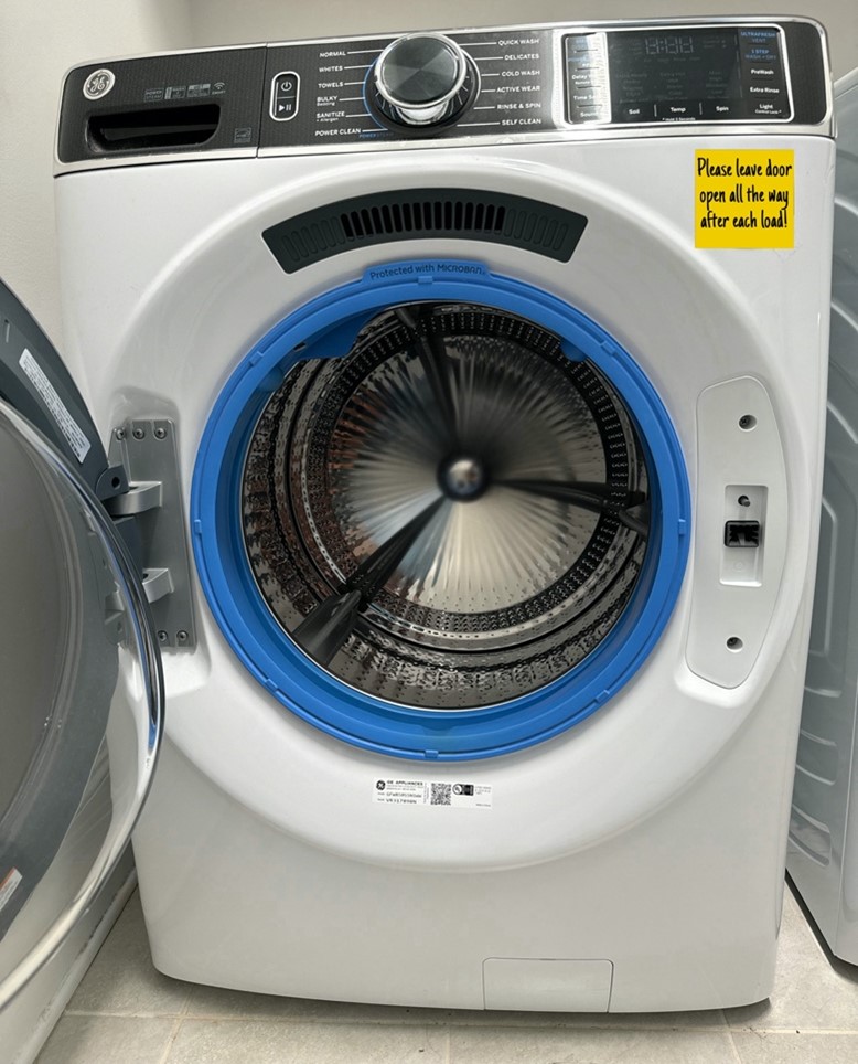 A GE Washer with the door open and a note