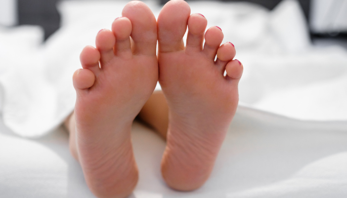 feet hanging off a mattress