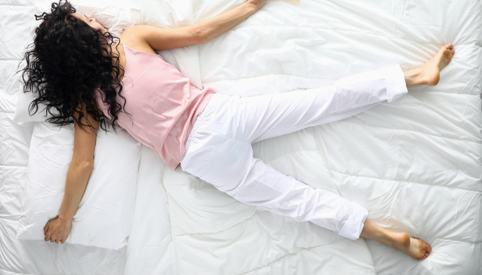 sleeping woman spread out on top of bed