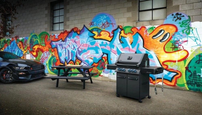 A Napoleon grill sitting in front of a wall