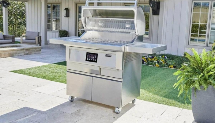 A Coyote grill ready to go in a backyard