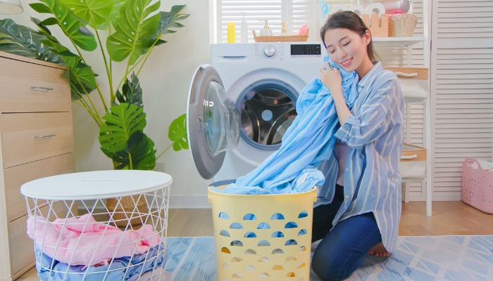 Woman feeling soft clean laundry after its done