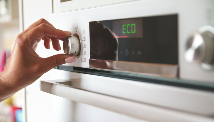 hand adjusting eco mode on wall oven