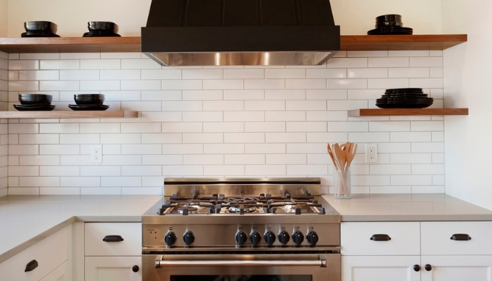 A professional gas stove in a white kitchen.