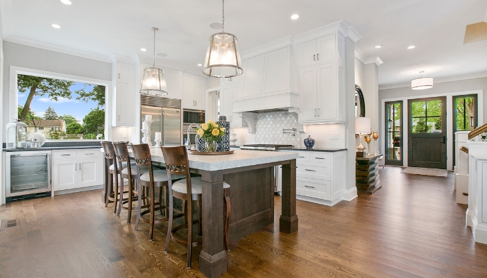 A luxury white kitchen with dark wood accents.