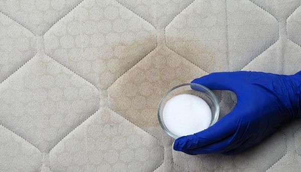 view of a person cleaning a sweat stain on a mattress