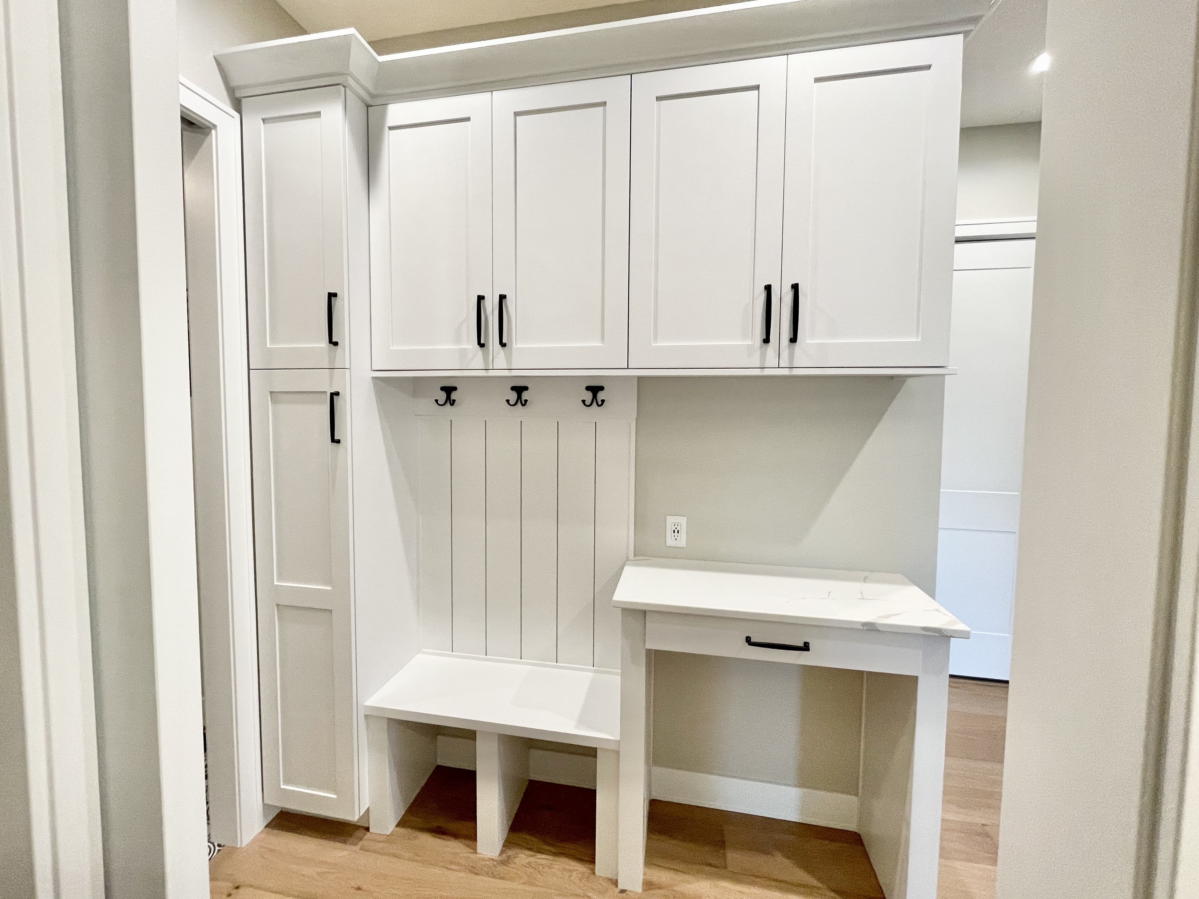 painted white cabinet dropzone with bench seat, cubbies, and coat hooks