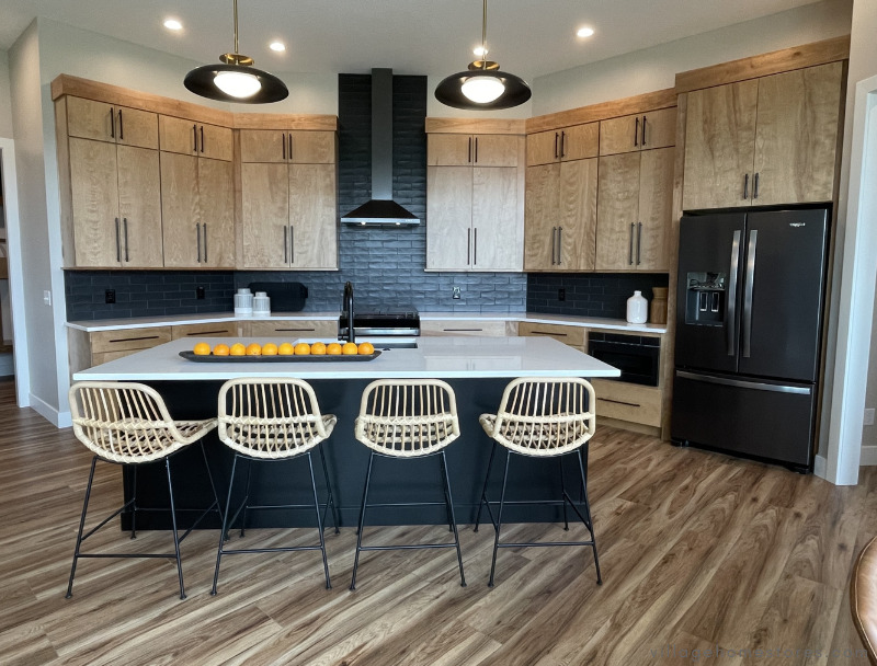 wide shot of modern kitchen design with wood and black cabinetry. Kitchen by Village Home Stores for Aspen Homes in Bettendorf